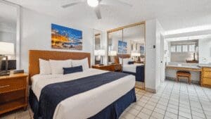 Hotel room with bed and mirrored closet.
