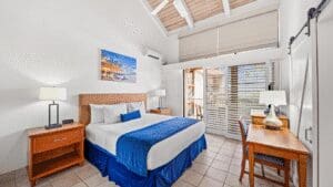 Bright hotel room with bed and desk.