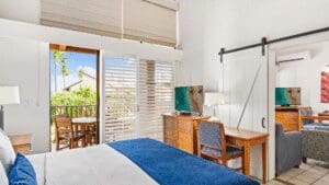 Bright hotel room with balcony and desk.