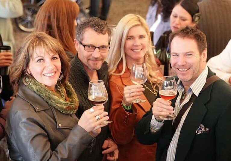 A group of people holding drinks at an event.