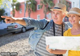 Smiling couple sightseeing with a map.